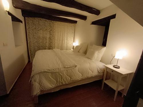um quarto com uma cama e uma mesa com 2 candeeiros em small House of La Reguera 