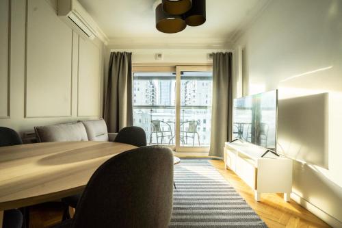 a room with a table and chairs and a large window at VipWarsawApartments Cytryn Mennica Residence in Warsaw