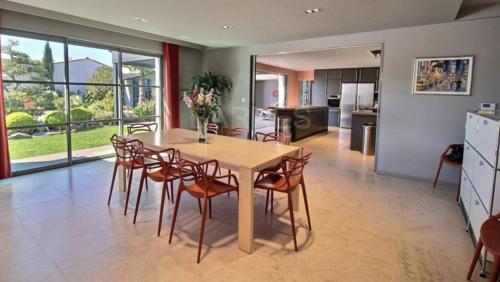 a kitchen and dining room with a table and chairs at ღ Villa des Astres 850 m2 - Piscine, Sauna, Hammam, & Salle de Cinéma in La Noue