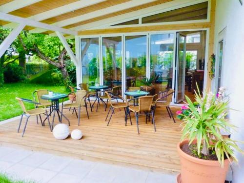 eine Terrasse mit Tischen und Stühlen auf einer Holzterrasse in der Unterkunft Gästehaus Spoth in Rust