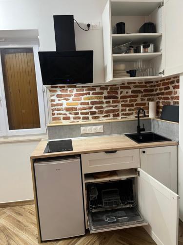 une cuisine avec un comptoir avec un évier et un micro-ondes dans l'établissement Studio à louer sur l application a i r b n b - Le Petit Fer à Cheval Centre-Ville, à Toulouse