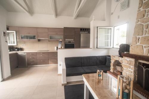 a living room with a couch and a kitchen at Ocean Waves - Alykes Beach in Drosia