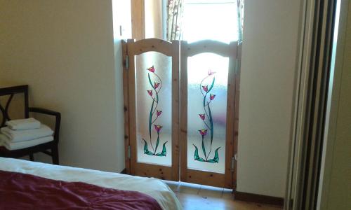 a bedroom with a door with flowers painted on it at Achill West Coast House in Dooagh