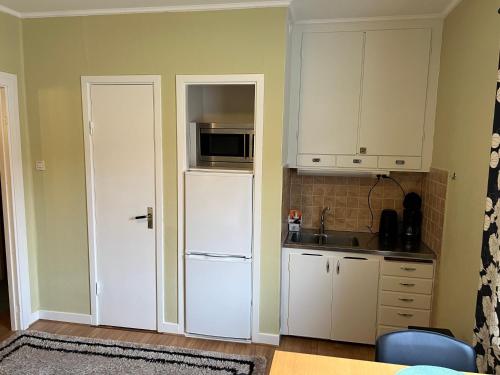 a kitchen with white cabinets and a white refrigerator at Central, university - centralt, högskolan in Halmstad