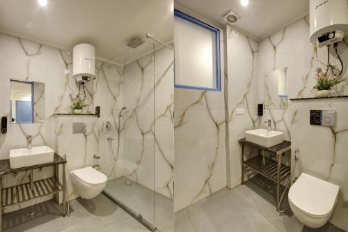 a bathroom with two sinks and a toilet at Hotel Elite 29 Golf Course Road in Gurgaon