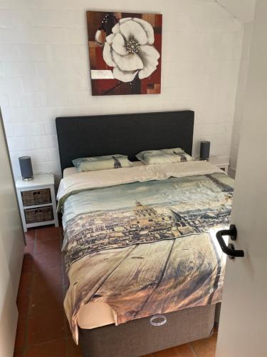 a bedroom with a bed with a flower painting on the wall at Gezellige Chalet met groot zonneterras in Domaine du Bonsoy - vernieuwd in 2024 in Blaimont