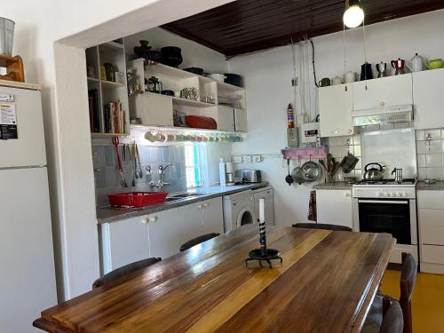 a kitchen with a wooden table and a kitchen with white cabinets at Oasis Cottage in Merweville in Merweville