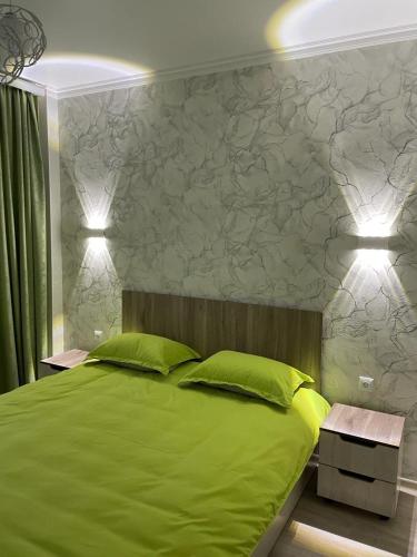 - une chambre avec un lit vert et 2 oreillers verts dans l'établissement 3х комнатная квартира, à Chimkent