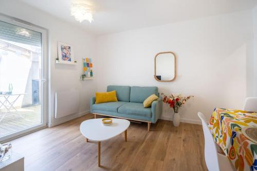 un salon avec un canapé bleu et une table dans l'établissement Le Patio de Juvénal, Beau T2, Patio, Centre Ville, à Montpellier