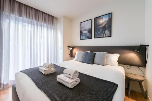 a bedroom with a large bed with towels on it at GuestReady - Three Mirrors in Porto
