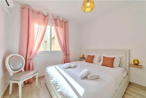 - une chambre avec un lit blanc, une chaise et une fenêtre dans l'établissement Agréable 3pièces Cannes Croisette, à Cannes