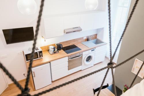 une cuisine avec un évier et une machine à laver dans l'établissement Studio Vichy mon amour Villa Marie Celine, à Vichy