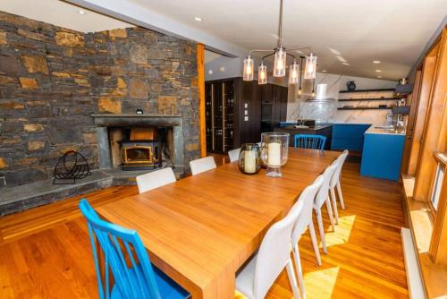 une salle à manger avec une table en bois et une cheminée dans l'établissement Luxury Mountain Mansion Huge Pool, Sauna, 7000sqft, à Windham