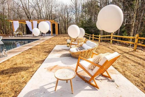 a backyard with chairs and a pool and a fence at Luxury Mountain Mansion Huge Pool, Sauna, 7000sqft in Windham