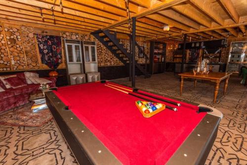 a room with a red pool table in a room at Luxury Mountain Mansion Huge Pool, Sauna, 7000sqft in Windham