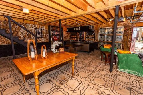 a room with a wooden table and a green couch at Luxury Mountain Mansion Huge Pool, Sauna, 7000sqft in Windham