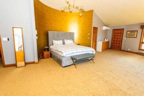 a large bedroom with a bed and a mirror at Luxury Mountain Mansion Huge Pool, Sauna, 7000sqft in Windham