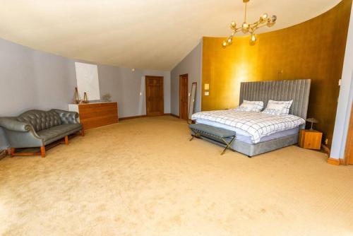 a large bedroom with a bed and a couch at Luxury Mountain Mansion Huge Pool, Sauna, 7000sqft in Windham