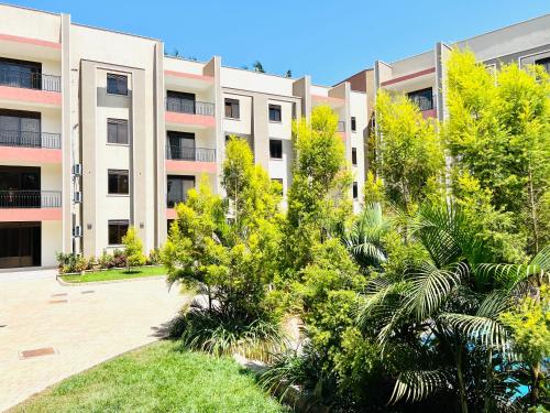 un edificio de apartamentos con árboles delante de él en Julie Heights Apartments en Kampala