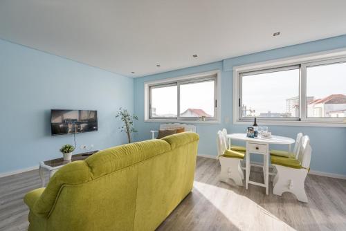 een woonkamer met een gele bank en een tafel bij GuestReady - Assuntos de recreio in Porto