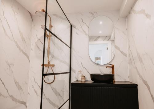 uma casa de banho com um lavatório preto e um espelho em Ostend Centre Bayview Apartment + Free Parking em Oostende