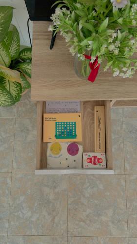 a toy shelf with boxes and flowers on a table at Fuerteventura Beach Vacations and Blue Mango surf&fitness center at charco in Puerto del Rosario