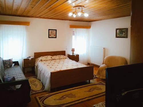 a bedroom with a bed and two chairs in it at Άγιος Μηνάς - Αστράκα View in Ágios Minás