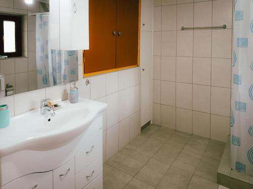 a bathroom with a sink and a mirror and a shower at Άγιος Μηνάς - Αστράκα View in Ágios Minás