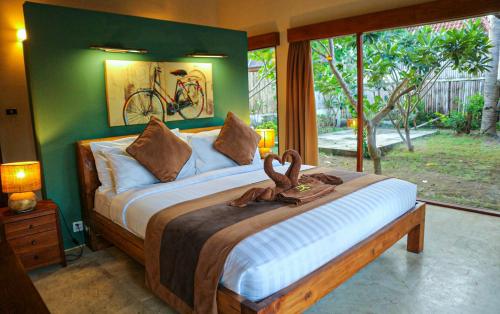 a bedroom with a bed with two swans on it at Dolce Magia in Gili Trawangan