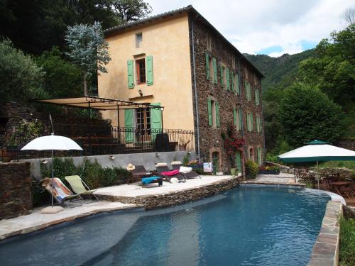une maison avec piscine devant un immeuble dans l'établissement La ferme du Valdeyron, à Valleraugue