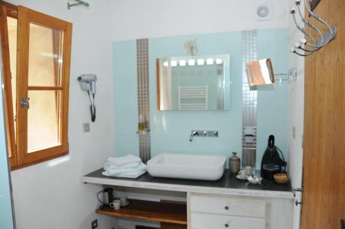 une salle de bain avec un lavabo et un miroir dans l'établissement La ferme du Valdeyron, à Valleraugue