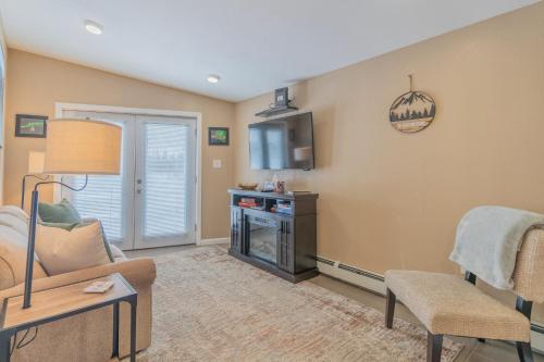 a living room with a couch and a tv at The Chena River House River Suite in Fairbanks