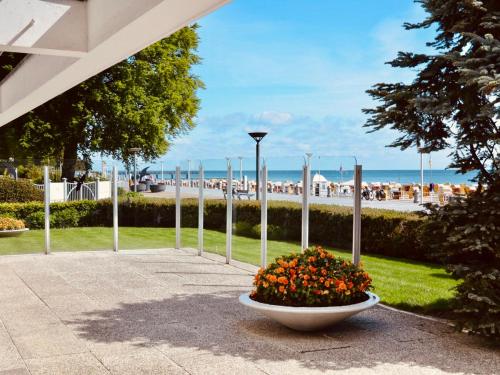 a bowl of flowers sitting on a sidewalk near the beach at Strand Suite in Lübeck