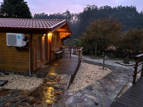 um deque de madeira ao lado de um chalé com um pátio em One bedroom property with enclosed garden and wifi at Falgaroso Da Serra Mortagua em Mortágua