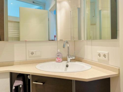 uma casa de banho com um lavatório e um espelho em Strand Suite em Lübeck