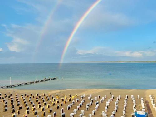 a group of umbrellas on a beach with a rainbow at Strand Suite in Lübeck