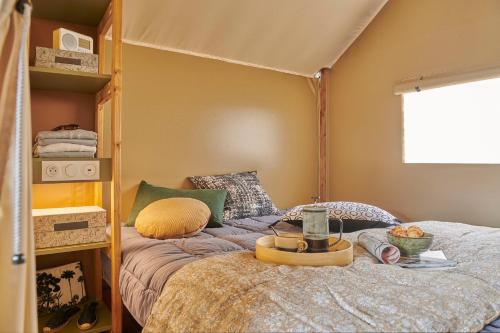 a bedroom with a bed with a canopy at Le Vallon aux merlettes in Matignon