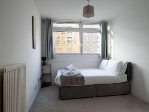 a small bedroom with a bed with a window at Pass the Keys Riverfront Comfort by the Thame in London