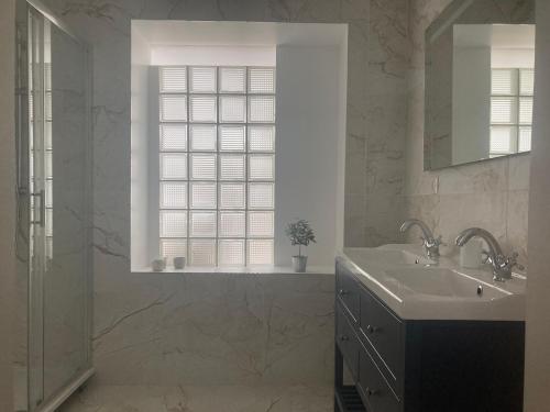 baño blanco con lavabo y ventana en La Villa de Puys - Dieppe, en Dieppe