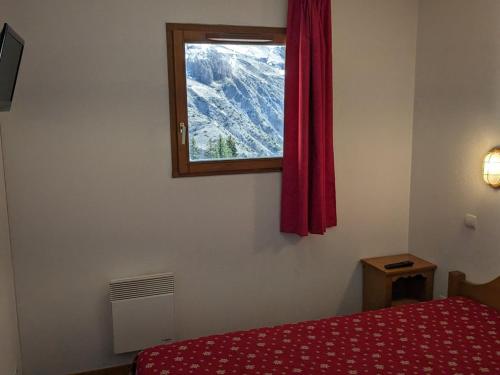 - une chambre avec un lit rouge et une fenêtre dans l'établissement Charmant 3 pièces, balcon, au pied des pistes, parking, WIFI - FR-1-262-154, à Les Estaris