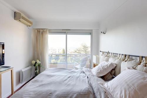 une chambre blanche avec un lit et une fenêtre dans l'établissement appartement Nice , terrasse panoramique mer, à Nice