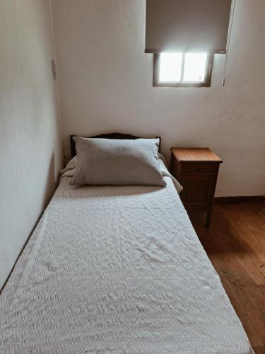 a bed in a small room with a window at La Casita Junin in Junín