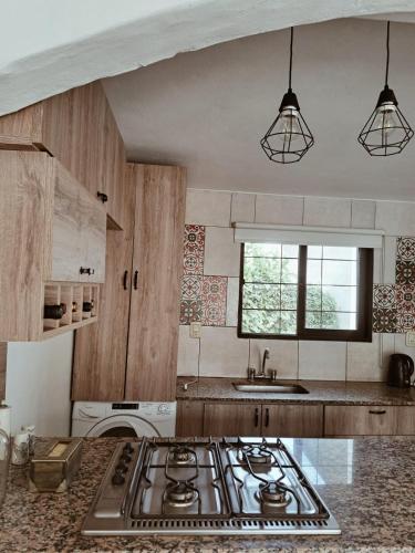 a kitchen with a stove top and a sink at La Casita Junin in Junín