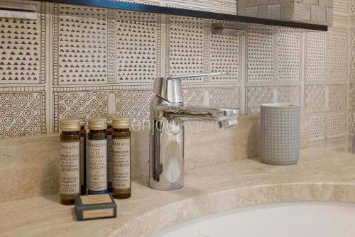 a bathroom with four bottles of essential oils on a sink at Palais Miramar - Suite & G17 - Vue Mer - Croisette Emplacement Unique -20 Plage - WIFI - Clim in Cannes