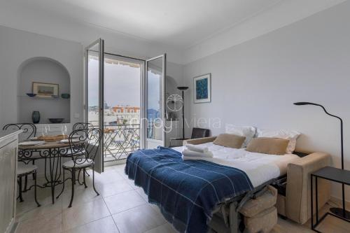 1 dormitorio con cama, mesa y balcón en Palais Miramar - Suite & G17 - Vue Mer - Croisette Emplacement Unique -20 Plage - WIFI - Clim en Cannes