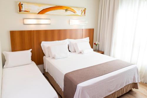 um quarto de hotel com duas camas e uma janela em Bourbon Joinville Convention Hotel em Joinville