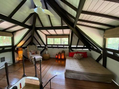 ペネドにあるDingo - Refugio romântico em meio à naturezaのベッド1台と天井ファン付きの屋根裏部屋