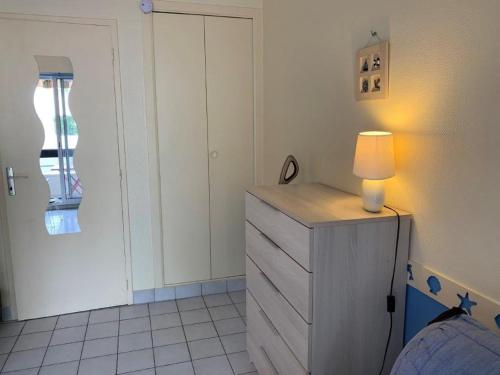 Un dormitorio con un tocador con una lámpara. en Saint Georges de Didonne - VACANCES à PETIT BUDGET - STUDIO CABINE, en Saint-Georges-de-Didonne
