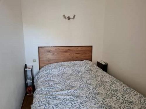 une chambre avec un lit avec une tête de lit en bois dans l'établissement Appartement 2 pièces 4 pers avec terrasse, parking privé et accès direct plage à Marseillan - FR-1-326-791, à Marseillan