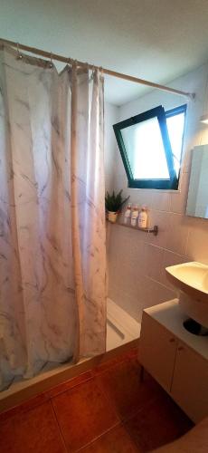 a bathroom with a shower curtain and a window at My casa Lanzarote in Costa Teguise